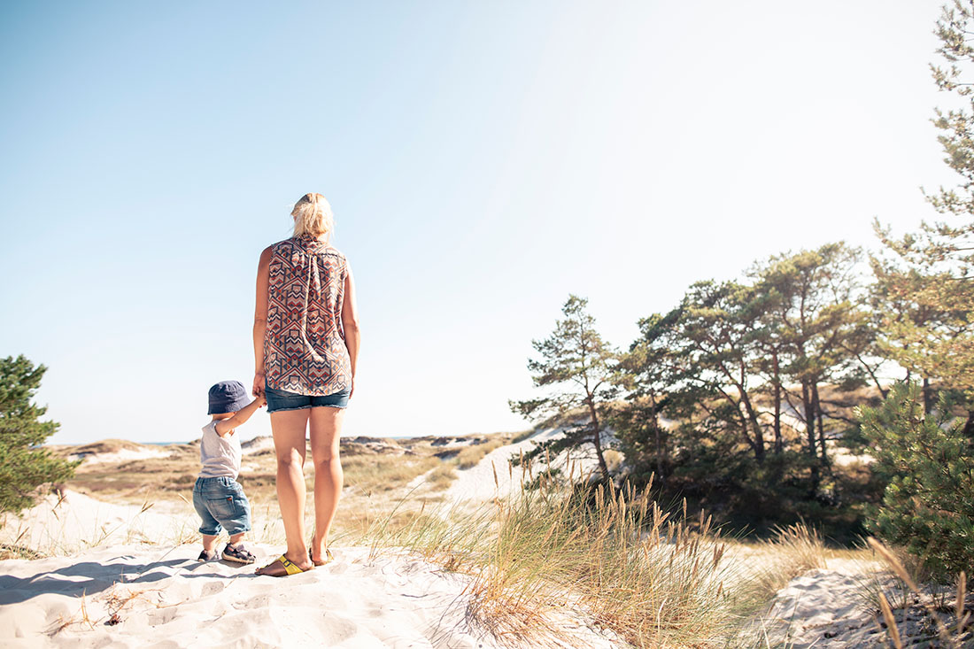 Mor og barn på hvid sandstrand