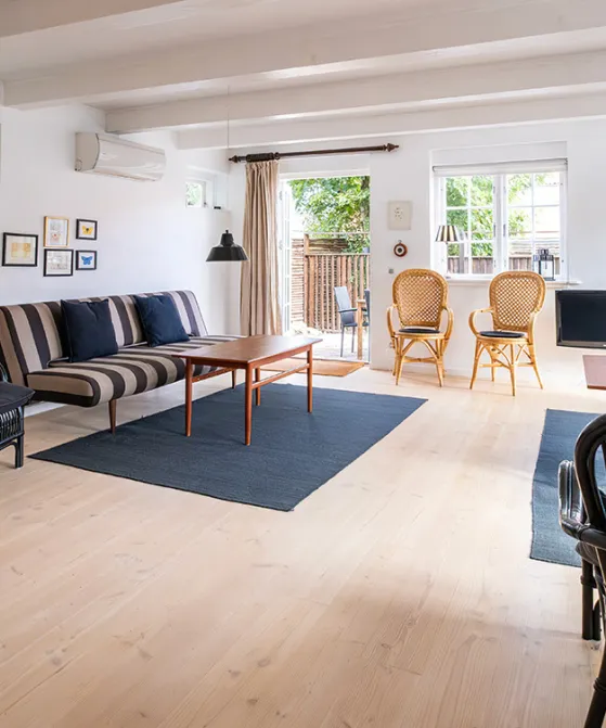 Stor stue med brændeovn og udgang til terrasse og have i Postgadehuset