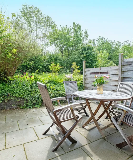 Terrasse med havemøbler i grønne omgivelser i ferielejlighed Gnisten