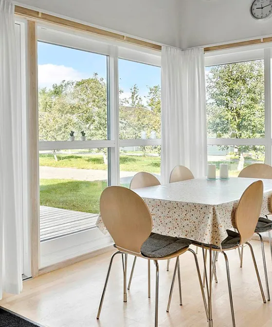 Stue med spiseplads og udgang til terrasse i Rø Golfhuse