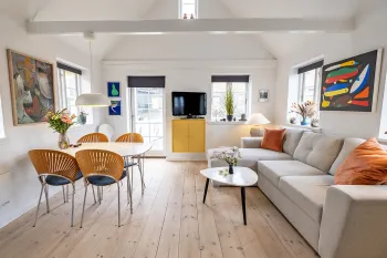 Lækkert opholdsrum med spiseplads og udgang til terrasse i Annekset