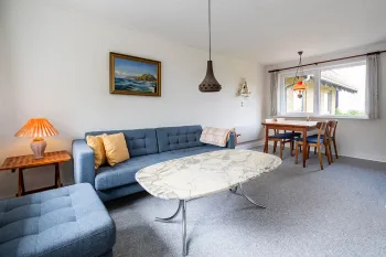 Stue med sofa og spisebord i ferielejlighed Gnisten