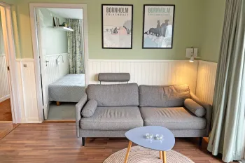 Opholdsrum med blød sofa i Friheden Ferielejligheder
