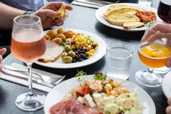 Middagsborg med tallerkner med mad fra buffeten og glas med vin på Abildgaard All-Inclusive