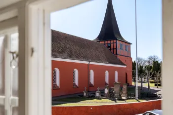 Udsigt til Svaneke kirke fra soveværelset i Kirkehuset 4A