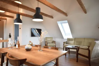 Opholdsrum med fritlagte bjælker og loft til kip i lejlighed Nyvang A