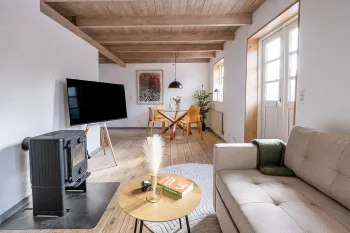 Flot opholdsrum med TV og brændeovn i Mosehuset