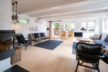 Stor stue med brændeovn og udgang til terrasse og have i Postgadehuset