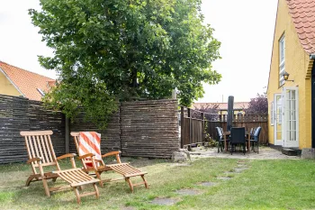 Grøn have og terrasse med havemøbler i Postgadehuset 