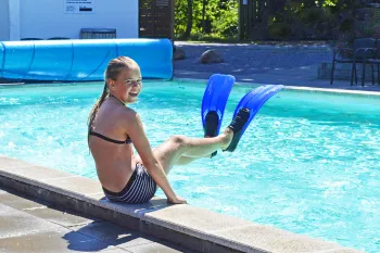 Pige med svømmefødder ved pool