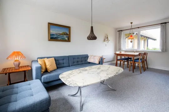Stue med sofa og spisebord i ferielejlighed Gnisten