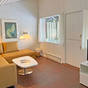 Opholdsrum på 1. sal med fjernsyn og sofa i feriehus for 4 personer med havudsigt i Hammershuse