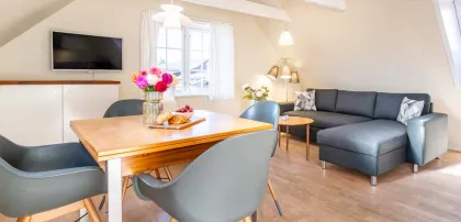 Stue i ferielejlighed med spiseplads og sofa