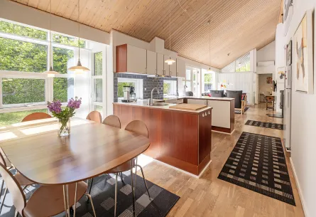 Stort køkken-alrum med loft til kip og store vinduer i Rubinhusene nr. 7