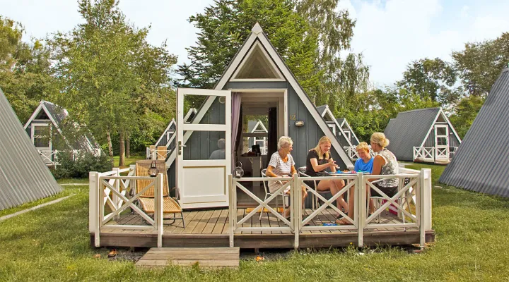 Familie hygger sig med brætspil på terrasse i Hasle Hytteby