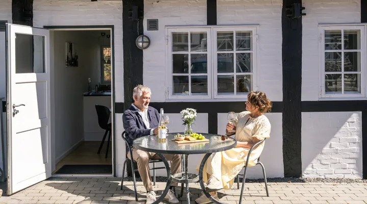 Par hygger sig på egen terrasse på Munken Ferielejligheder