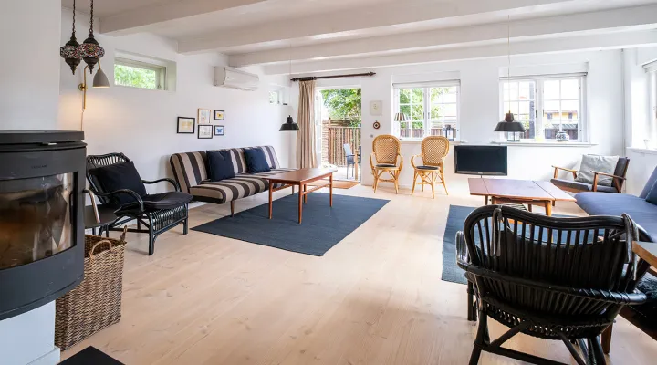 Stor stue med brændeovn og udgang til terrasse og have i Postgadehuset