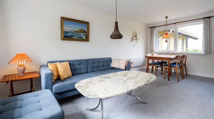 Stue med sofa og spisebord i ferielejlighed Gnisten