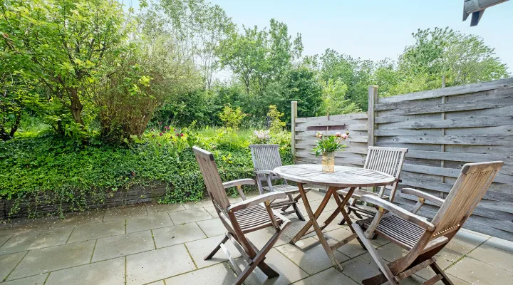 Terrasse med havemøbler i grønne omgivelser i ferielejlighed Gnisten