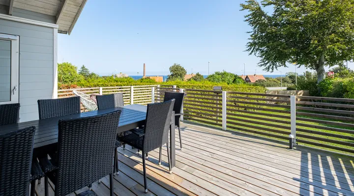 Dejlig træterrasse med havemøbler og havkig i Bornhamas