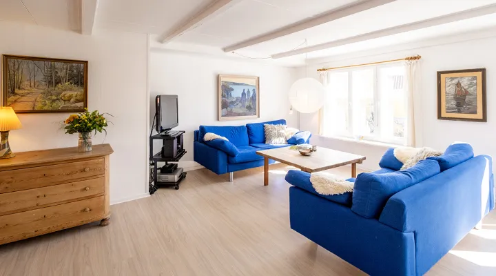 Stue med sofaer og TV i ferielejlighed Kirkehuset 4A