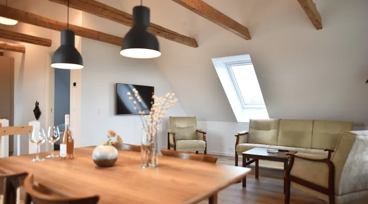 Opholdsrum med fritlagte bjælker og loft til kip i lejlighed Nyvang A