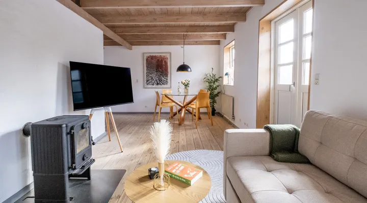 Flot opholdsrum med TV og brændeovn i Mosehuset