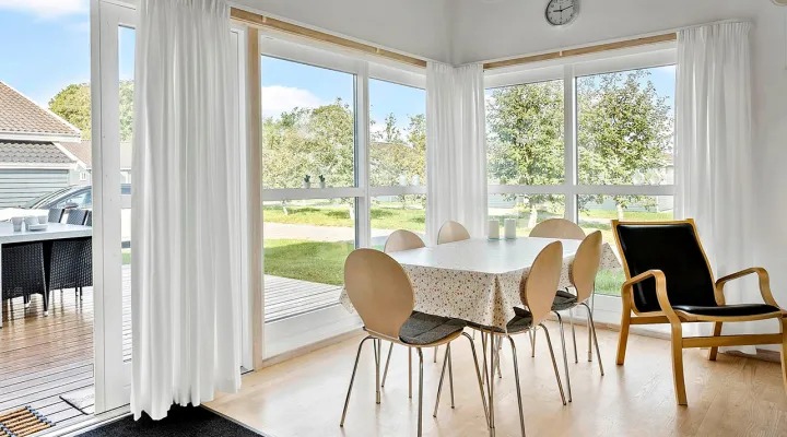 Stue med spiseplads og udgang til terrasse i Rø Golfhuse