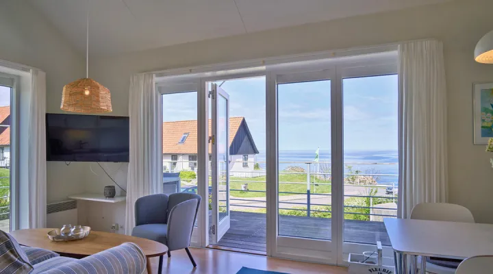Opholdsrum med udgang til terrasse med havudsigt i Gudhjem Feriehuse