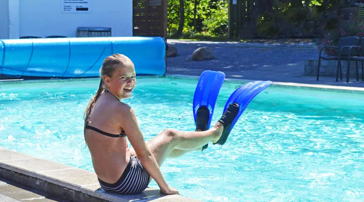 Pige med svømmefødder ved pool