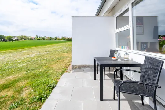 Privat terrasse med udsigt over marker og kyststrækningen i Boesvang nr. 24