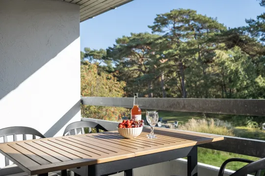 Nyd udsigten over det grønne fællesareal fra din balkon eller terrasse i Dueodde Strand Ferielejligheder