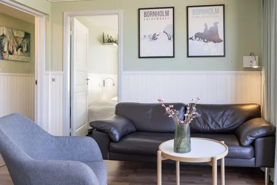 Stue med sofa og lænestole i Friheden Ferielejligheder