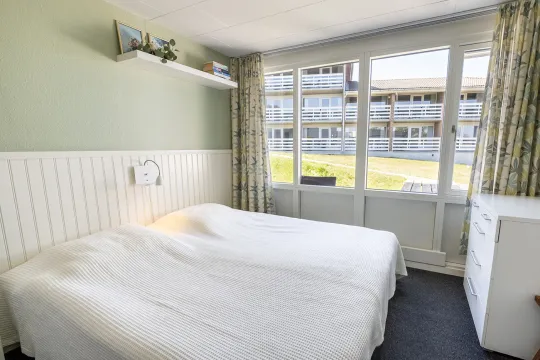 Soveværelse med dobbeltseng i Friheden Ferielejligheder