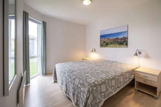 Soveværelse med dobbeltseng i ferielejlighed i Gudhjem Søpark