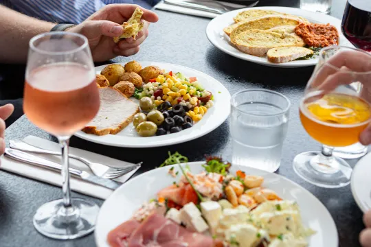 Middagsborg med tallerkner med mad fra buffeten og glas med vin på Abildgaard All-Inclusive