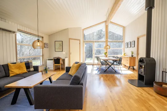 Stort opholdsrum med brændeovn og udgang til terrasse i Rubinhusene nr. 19