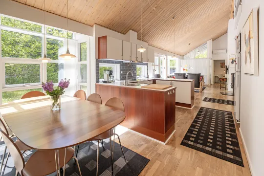Stort køkken-alrum med loft til kip og store vinduer i Rubinhusene nr. 7