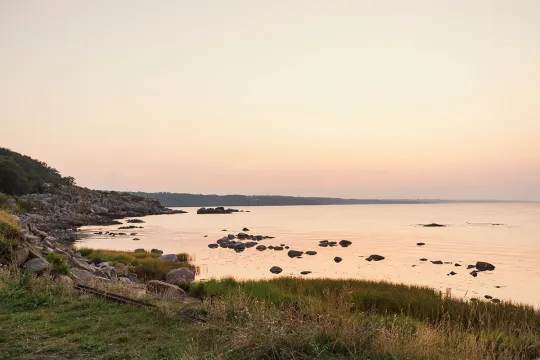 Klar aftenhimmel over vand og klipper ved Svaneke